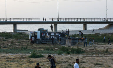 people carry goods away from a truck