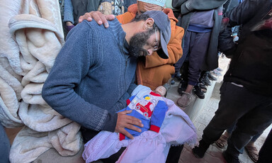 A man prepares his infant for burial