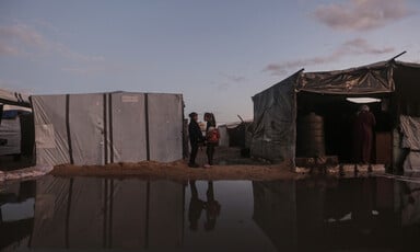 a large puddle lies between two tents