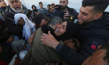 A woman hugs a man amidst a crowd of people