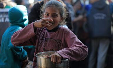 A child eats from a pot