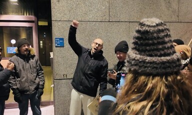 The Canadian activist Yves Engler raises his fist in the company of family and friends