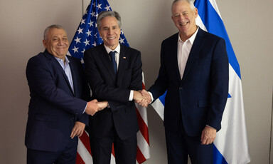 Israeli politician Gadi Eisenkot stands beside then US Secretary of State Antony Blinken and Benny Gantz, another Israeli politician, with flags behind them