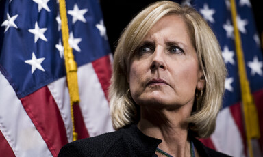 Congresswoman Claudia Tenney with two American flags behind her