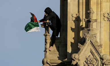 A man waves the Palestinian flag from a perch on Big Ben