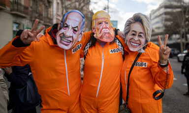 Three people wear orange jump suits and masks of Israel's Benjamin Netanyahu, America's Donald Trump and the European Union's Ursula von der Leyen