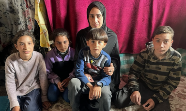 A woman sits with four children
