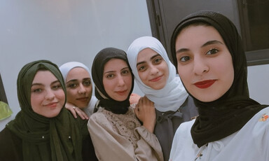 Five young women give slight smiles in selfie photo