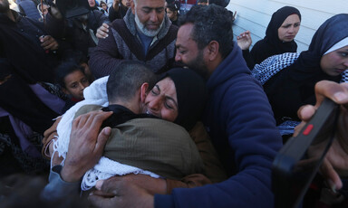 A woman hugs a man amid a crowd,