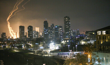 City skyline with bright smoke trails from missiles