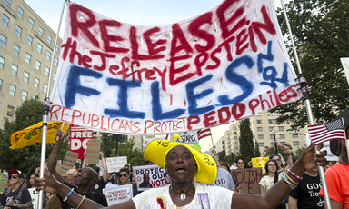 Demonstrators hold a sign reading: Release the Jeffrey Epstein files now