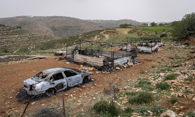 Landscape view of burned-out car and tent structures