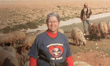 JoAnne Lingle in foreground and a man with sheep in background