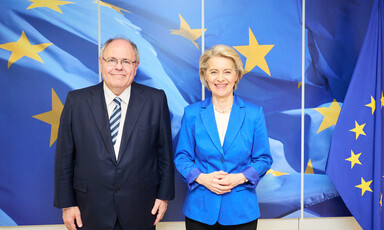 Israeli settler leader Dani Dayan stands beside European Commission President Ursula von der Leyen in front of a blue and yellow backdrop