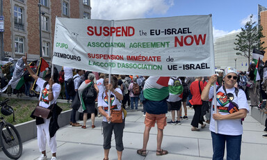 Three women hold a sign saying Suspend the EU-Israel Association Agreement