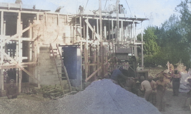 A home is seenunder construction, with piles of materials and various wood scaffolding