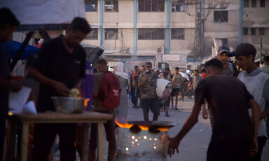A street vendor prepares falafel at dusk