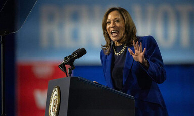 Kamala Harris gesticulates from behind a podium