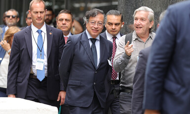 A man in a suit flanked by others in suits