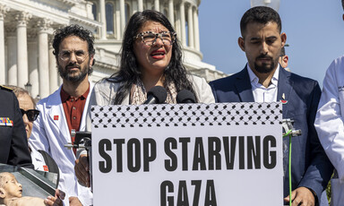 Congresswoman Rashida Tlaib speaks outside the US Capitol Building alongside medical professionals and Palestinian rights advocates and a sign reading "Stop starving Gaza"