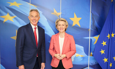 Former British Prime Minister Tony Blair stands beside European Commission President Ursula von der Leyen in front of a blue backdrop featuring yellow stairs
