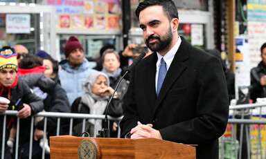 Mayor Zohran Mamdani speaks at podium with people onlooking