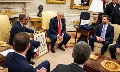 Germany's Chancellor Friedrich Merz holds a framed document as he sits beside US President Donald Trump and US Vice-President JD Vance 