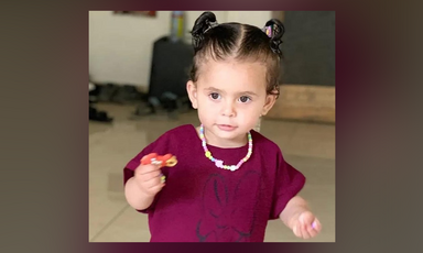 A girl holds a pacifier