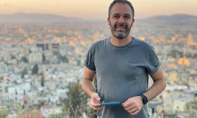 Smiling man seen against backdrop of Palestinian city