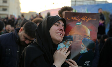 A woman embraces a portrait of Ali Khamenei