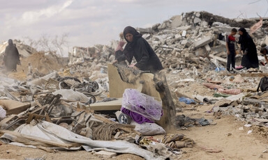 A woman sifts through rubble