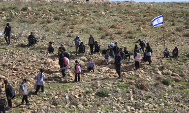 Children in a field near an Israeli flag