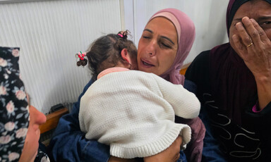 A woman holds her toddler to her chest