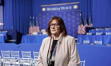 European Union Commissioner Dubravka Šuica stands in front of several US flags and a sign reading Board of Peace 
