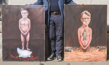 A man holds up two paintings