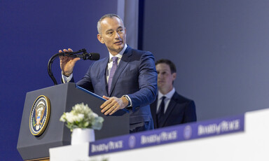 Man in suit speaks from a podium